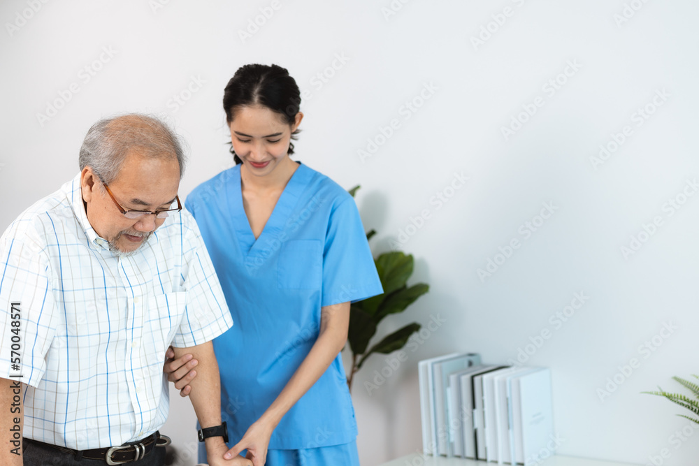 Happy smiling nurse in hospital and clinic uniform helping senior man with spectacles walk using a walker in the passage and corridor after successful treatment and physiotherapy Happy smiling nurse in hospital and clinic uniform helping senior man with spectacles walk using a walker in the passage and corridor after successful treatment and physiotherapy