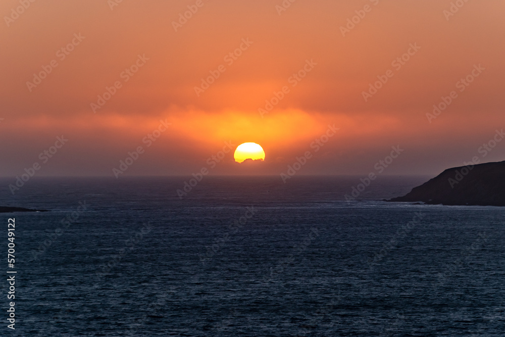Sun Going Down Over the Horizon and Pacific Ocean in Bodega Bay California