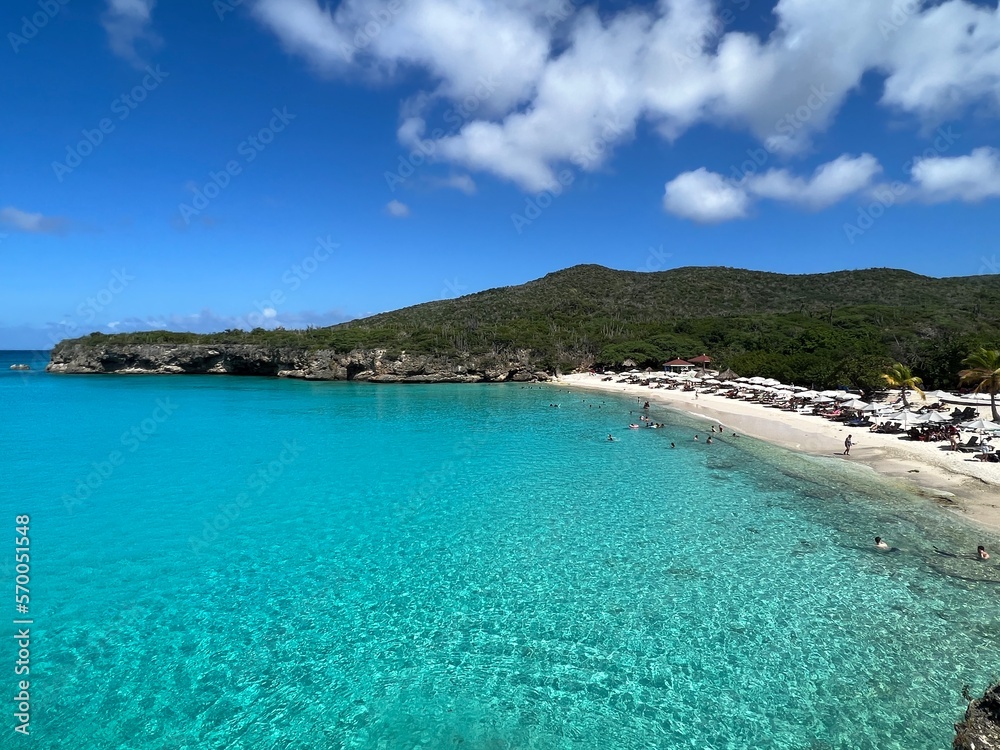 Fototapeta premium Grote Knip beach view of crystal clear blue green water in the carribean with a blue sky back ground. Curacao West Punt