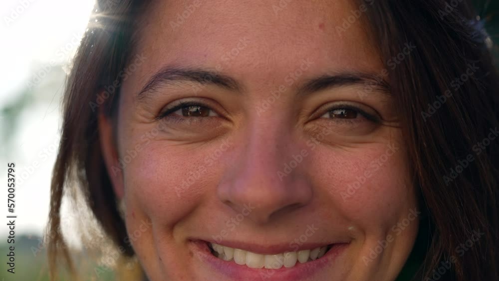 Portrait close up of a woman smiling to camera. Happy expression of female person with sunlight flare. Macro closeup Portrait close up of a woman smiling to camera. Happy expression of female person with sunlight flare. Macro closeup