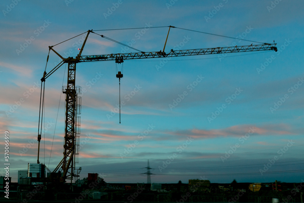 black crane silhouette against blue sky at sundown