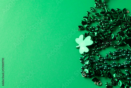 Image of green clover and jewellery and copy space on green background