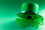 Image of green hat, green clover glasses and copy space on green background