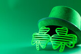 Image of green hat, green clover glasses and copy space on green background