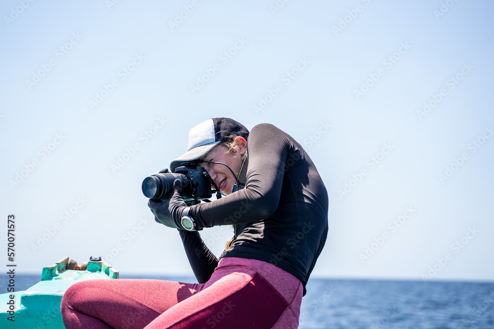 Obraz premium Concentrated marine biologist talking photos in on a boat
