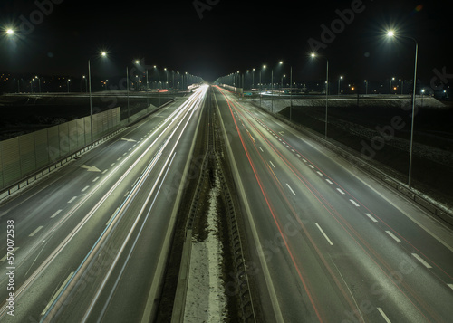 widok świateł pędzących oświetloną autostradą aut nocą