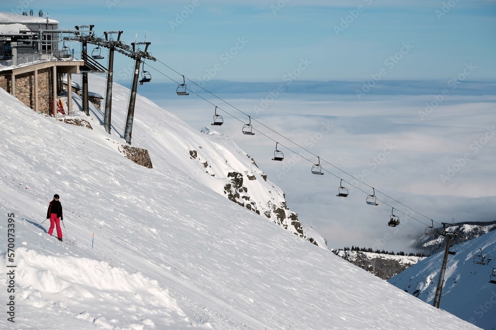 Beautiful winter scenery of Kasprowy Wierch Peak in Tatras Mountains, famous place in Tatras with cable railway. Poland. Tatra National Park. Silhouette of skier on trail. 