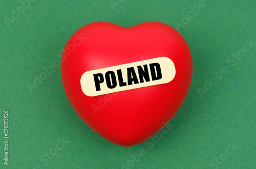 On a green surface lies a red heart with the inscription - Poland