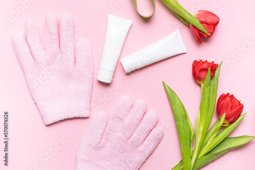 Spa gel gloves  hand care cream and mask and fresh red tulips on light pink background top view. Skin care concept.