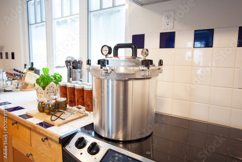 Home Canning jalapenos in jars and a batch of chili with a pressure cooker. Food preservation is key to gardening and homesteading. Pressure canning makes food shelf stable. 
