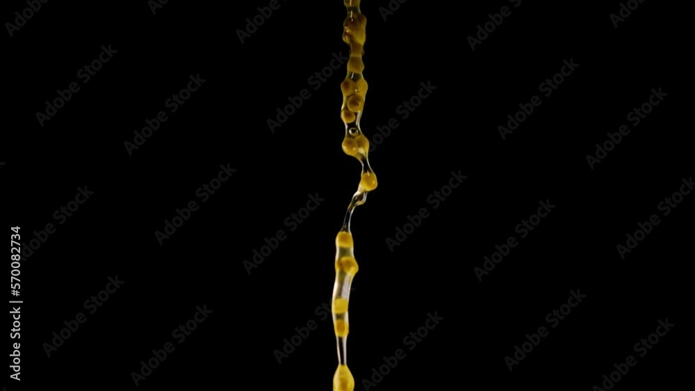 String of numerous delicious canned sweet green peas with spicy marinade fall down on black background closeup slow motion String of numerous delicious canned sweet green peas with spicy marinade fall down on black background closeup slow motion