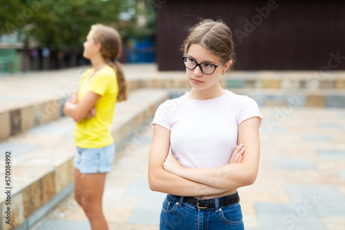 Offended girl turned away from her friend after quarrel on the street © JackF
