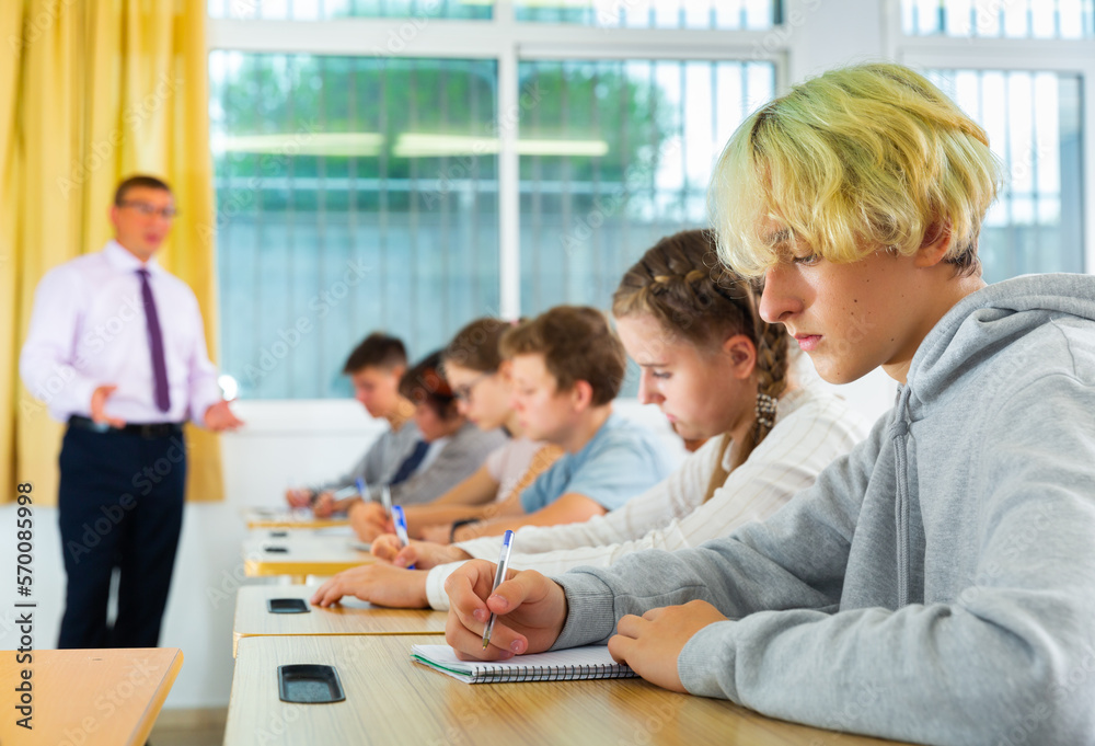© JackF - Group of teenage high school students diligently working in class, making notes of teacher lecture © JackF - Group of teenage high school students diligently working in class, making notes of teacher lecture