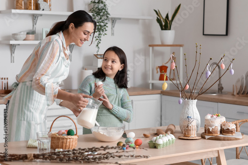 Photography Little girl and her mother making dough for Easter cake in kitchen