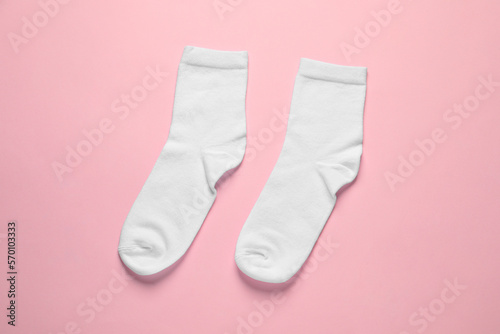 Pair of white socks on pink background, flat lay