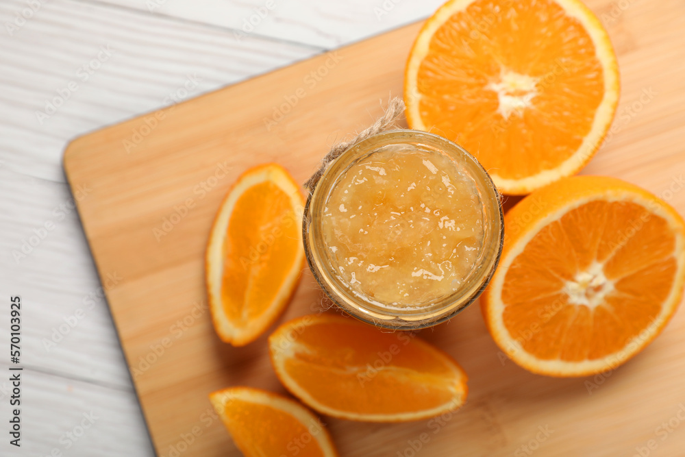 Jar of delicious orange jam and fresh fruits on white wooden table, top view