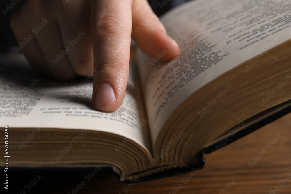 Man reading holy Bible at wooden table, closeup Man reading holy Bible at wooden table, closeup