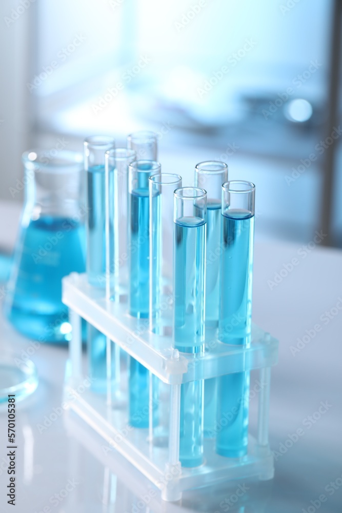 Test tubes with light blue liquid in laboratory, closeup Test tubes with light blue liquid in laboratory, closeup