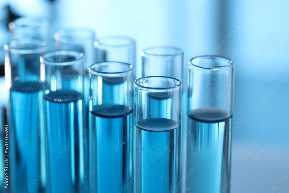 Test tubes with light blue liquid in laboratory, closeup