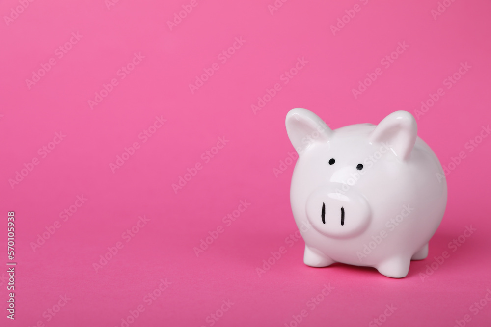 Ceramic piggy bank on pink background, space for text. Financial savings