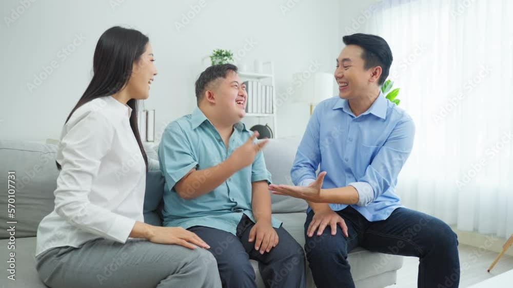 Asian parents and son with autism spend leisure time together at home. Asian parents and son with autism spend leisure time together at home.