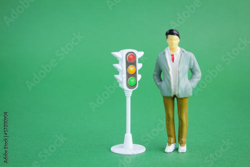 miniature people with traffic lights on the side. traffic light compliance concept photo