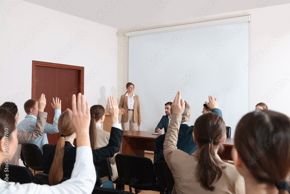 Fototapeta premium People raising hands to ask questions at business conference in meeting room