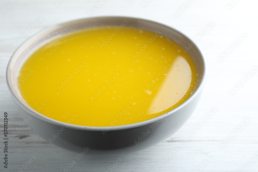 Clarified butter in bowl on white wooden table, closeup Clarified butter in bowl on white wooden table, closeup