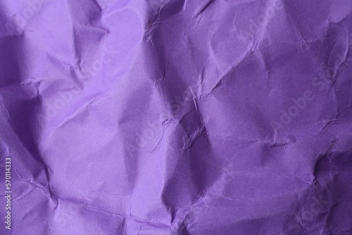 Sheet of crumpled violet paper as background, top view