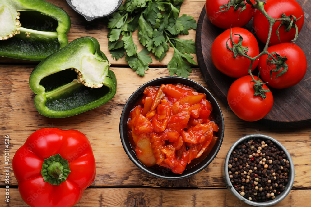 Delicious lecho and ingredients on wooden table, flat lay Delicious lecho and ingredients on wooden table, flat lay