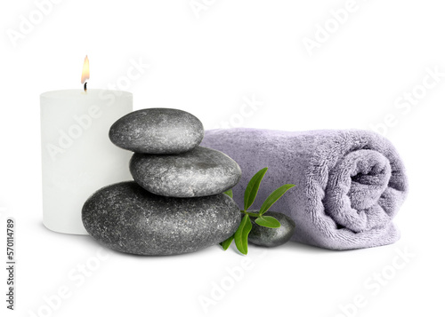 Beautiful composition with burning candle, stacked stones and rolled towel on white background. Spa therapy