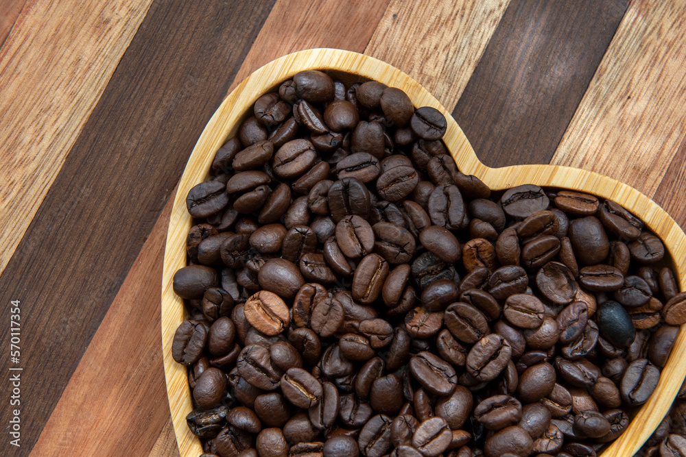 Fototapeta premium coffee beans in heart-shaped tra,y representing love of coffee