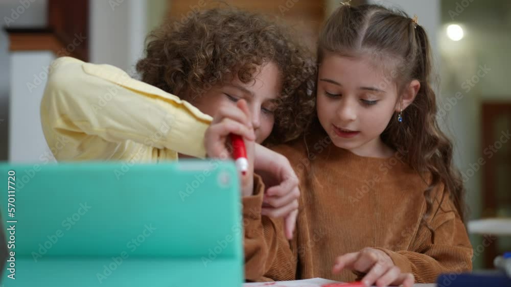 Happy Caucasian schoolchildren painting talking laughing sitting at table indoors. Portrait of positive talented boy and girl enjoying studies drawing at home. Lifestyle and creativity concept Happy Caucasian schoolchildren painting talking laughing sitting at table indoors. Portrait of positive talented boy and girl enjoying studies drawing at home. Lifestyle and creativity concept