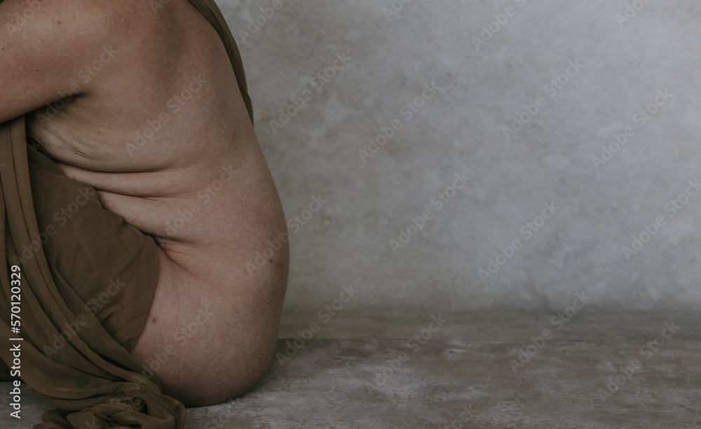 Fototapeta premium side profile of non-binary person showing skin texture and body rolls