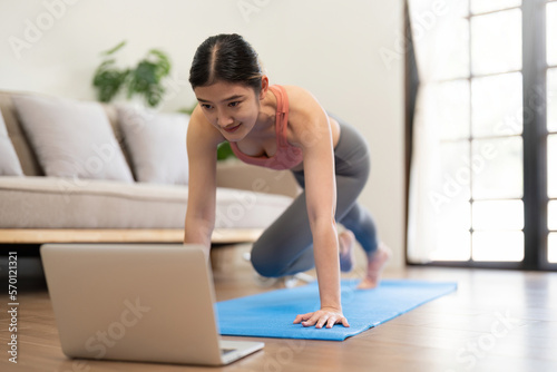 Young woman Exercising At Laptop Having Online Training At Home