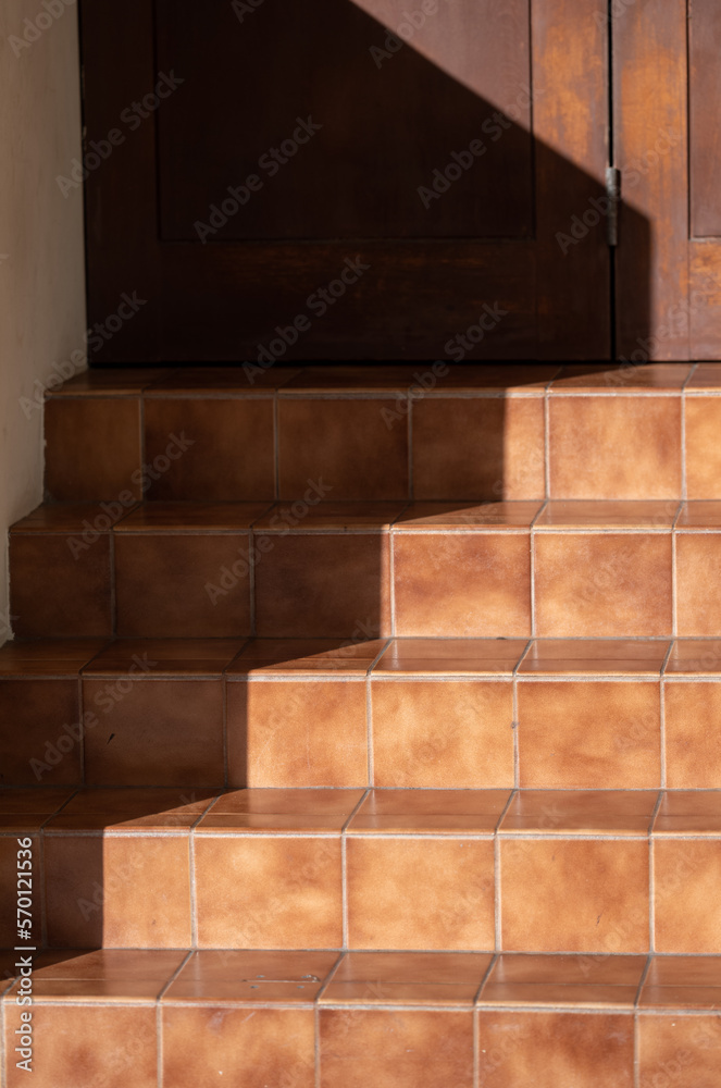 Burnt Sienna Tile Staircase in Sunlight with a Shadow.