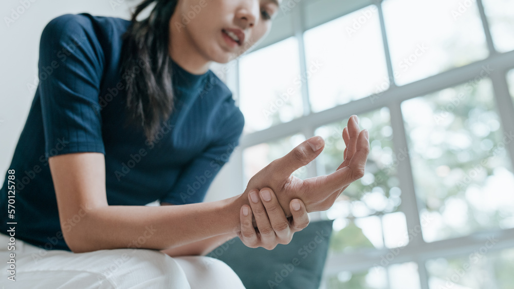 Unhappy Asian woman suffering from pain in arm Unhappy Asian woman suffering from pain in arm