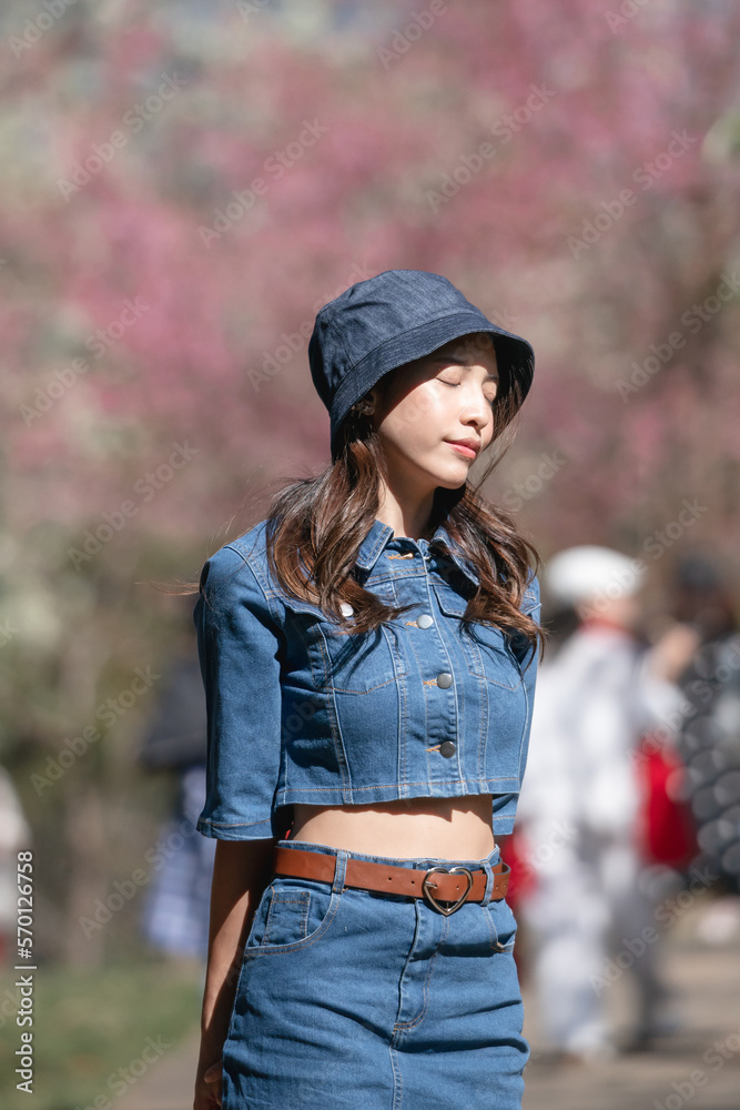 Woman with cherry blossoms or sakura flower blooming in the park Woman with cherry blossoms or sakura flower blooming in the park