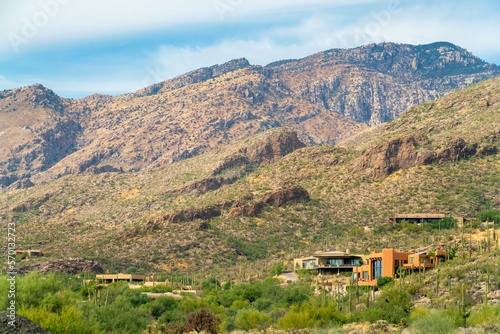 Towering mountains in late afternoon sun with houses and homes on ridge in sonora desert with hilltop locations