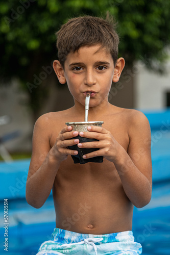 male child in swimsuit drinking traditional argentinian mate meme