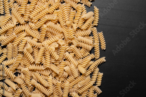  raw shaped pasta with space for text on black table in white light