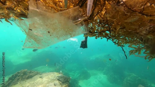 Trash Bag and Underwater Pollution Floating in the Ocean photo