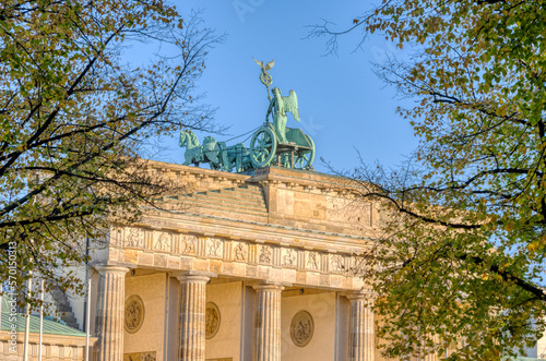 The backside of the famous Brandenburg Gate in Berlin seen through some trees photo