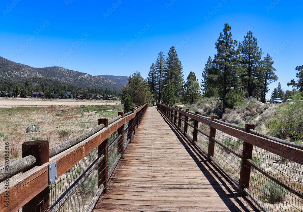 The elevated wooden bridge and the road next to it at the Dry Stanfield Marsh Wildlife and Waterfowl Preserve in Big Bear Lake, California The elevated wooden bridge and the road next to it at the Dry Stanfield Marsh Wildlife and Waterfowl Preserve in Big Bear Lake, California