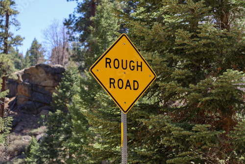 A yellow diamond shape Rough Road sign.