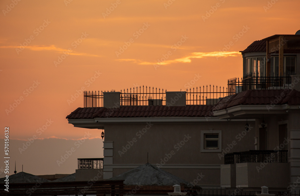 silhouette of the roof of the house on the background of the sunset.