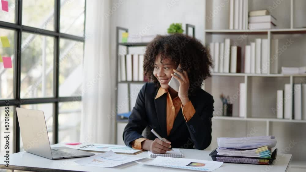 Young African businesswomen working and talking with happy and smile face on a phone calling to client and colleague in office space. Young African businesswomen working and talking with happy and smile face on a phone calling to client and colleague in office space.