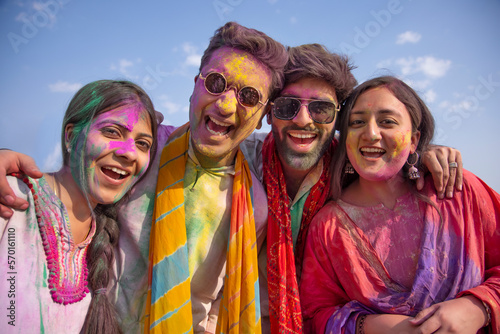 a group of young friends posing together happily during holi celebrations