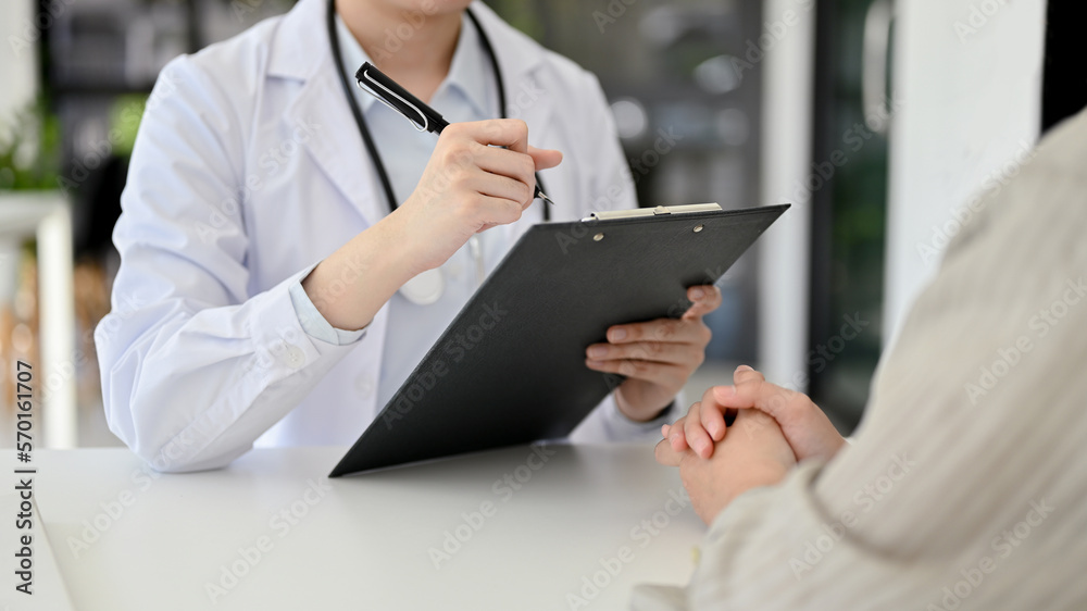Professional female doctor meets with a patient in the office, diagnosing the patient. cropped Professional female doctor meets with a patient in the office, diagnosing the patient. cropped