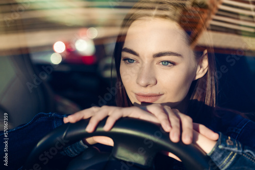Nice young lady happy car. Image beautiful young woman who drives car and smiles. Portrait of a steering car with a driver of a happy woman with a seat belt